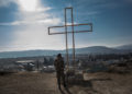 Un soldato armeno prega ai piedi di una croce in una postazione militare a Martakert, Nagorno-Karabakh