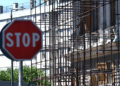 Un cartello di stop e impalcature per la ristrutturazione edilizia a Genova